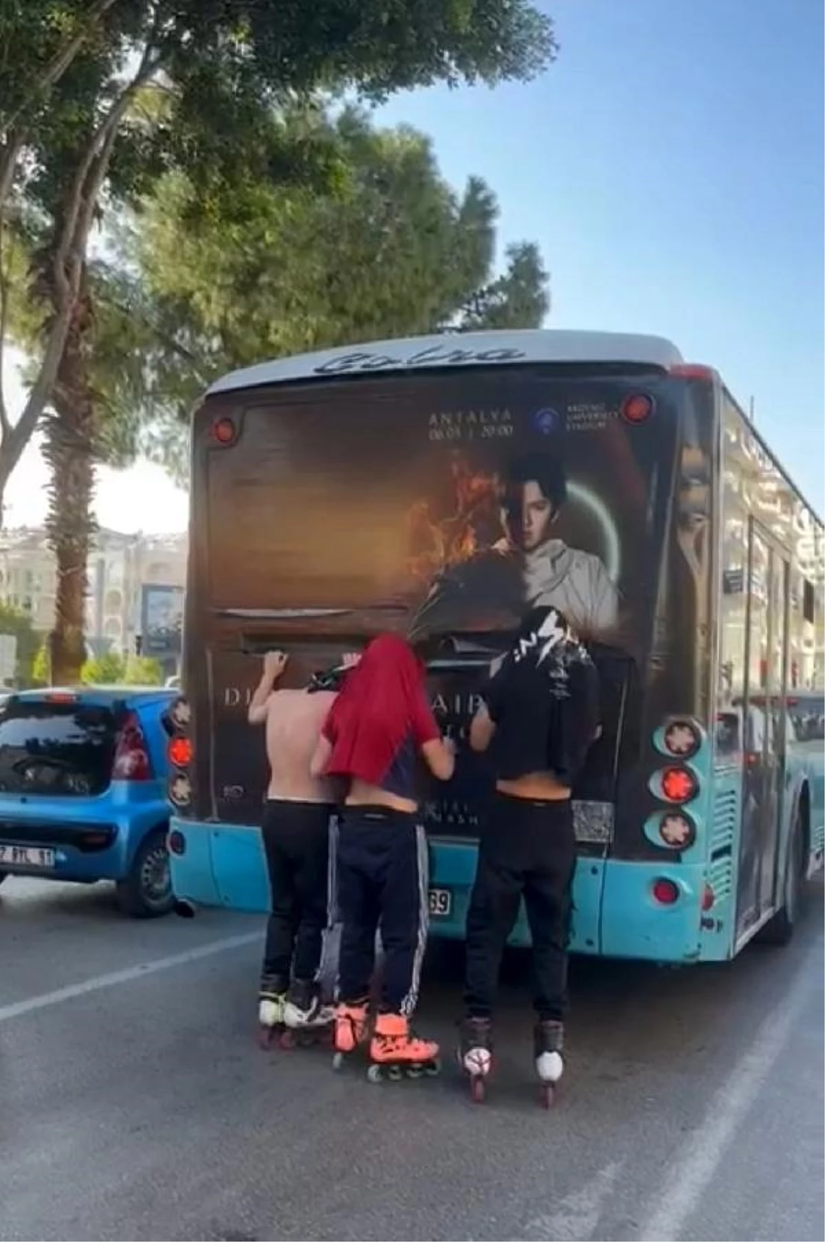Patenli gençler, halk otobüsünün gerisine tutunup ilerledi
